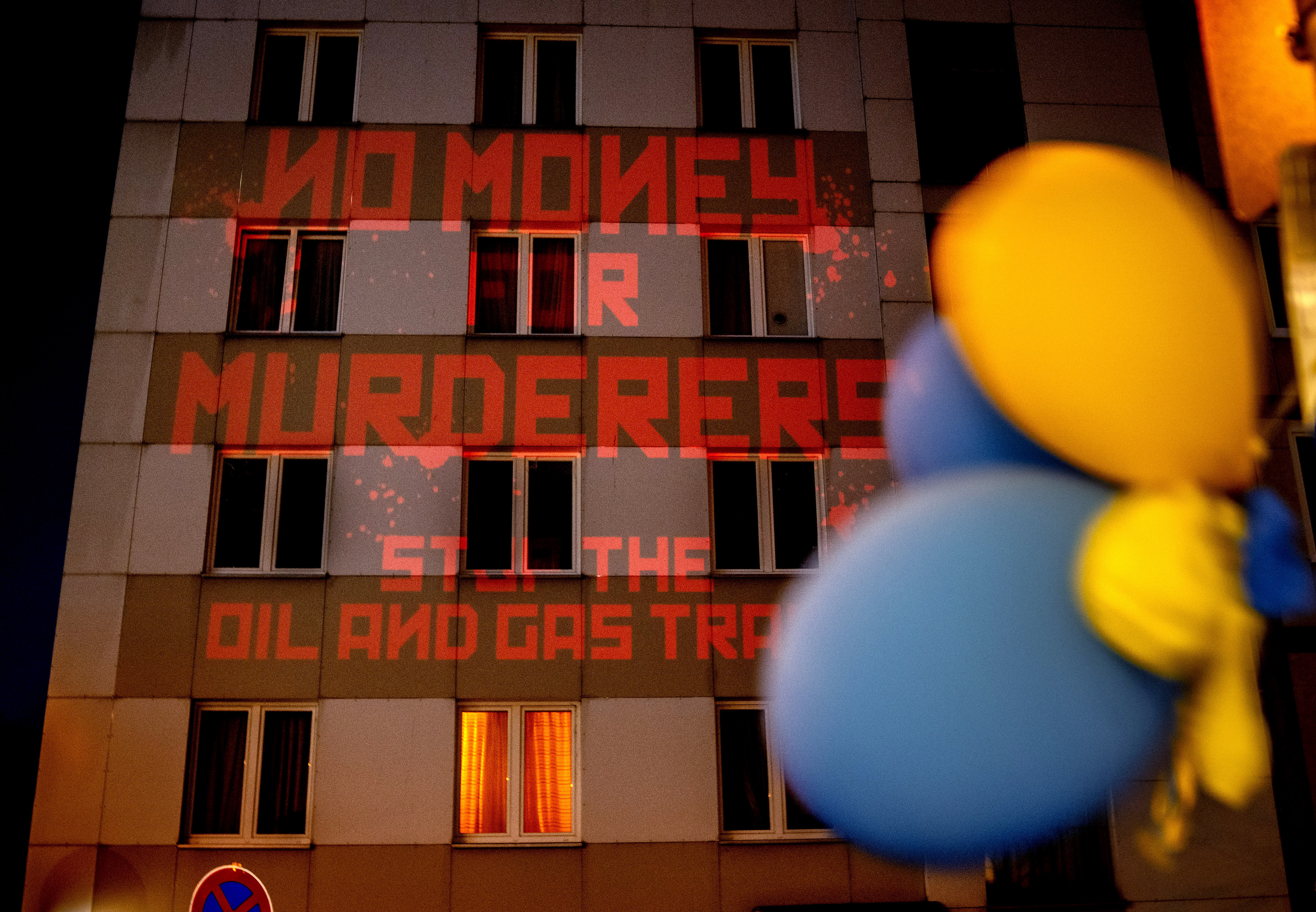 “不要钱给凶手，停止石油和天然气贸易”的字样被投影到墙上俄罗斯驻德国领事馆。